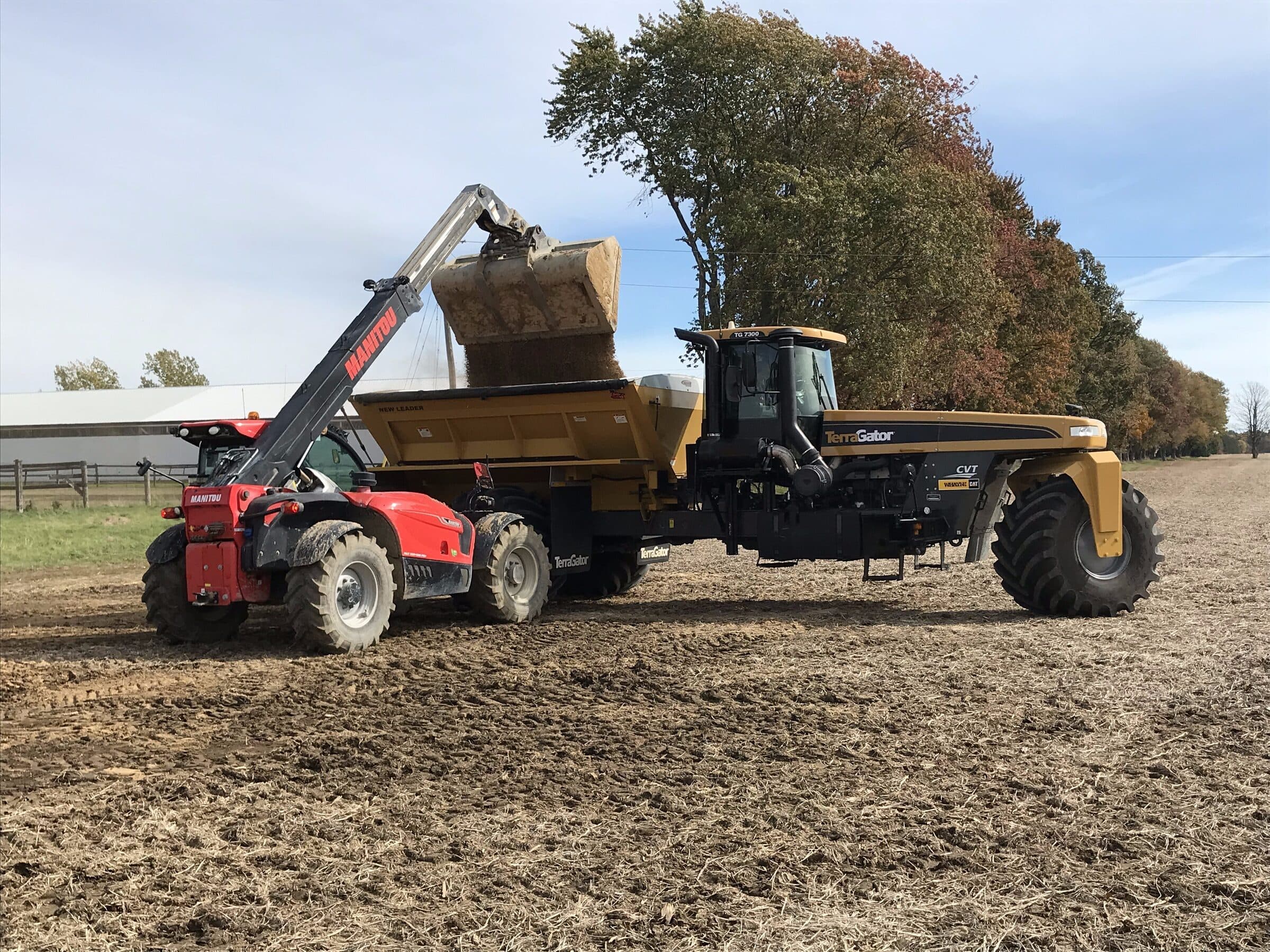 Telehandler loading N-Rich into a TerraGator floater spreader on an Ontario farm